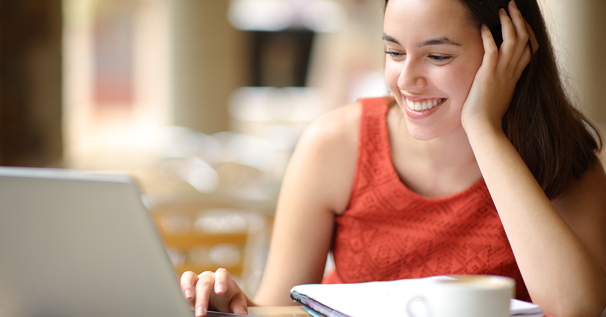 smiling college woman student working on a laptop