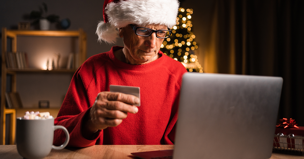man with santa hat and credit card at a computer