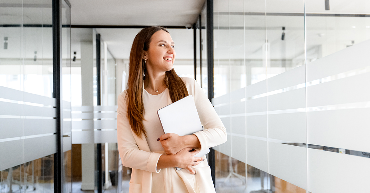 smiling woman walking down an office hallway